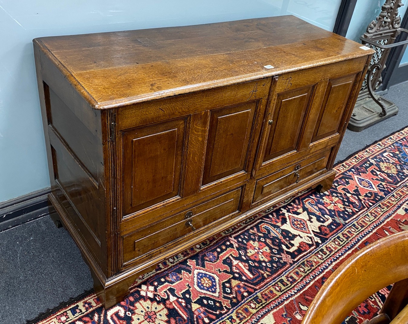 An 18th century panelled oak mule chest, initialled to the frieze A.B, altered, length 125cm, depth 51cm, height 77cm